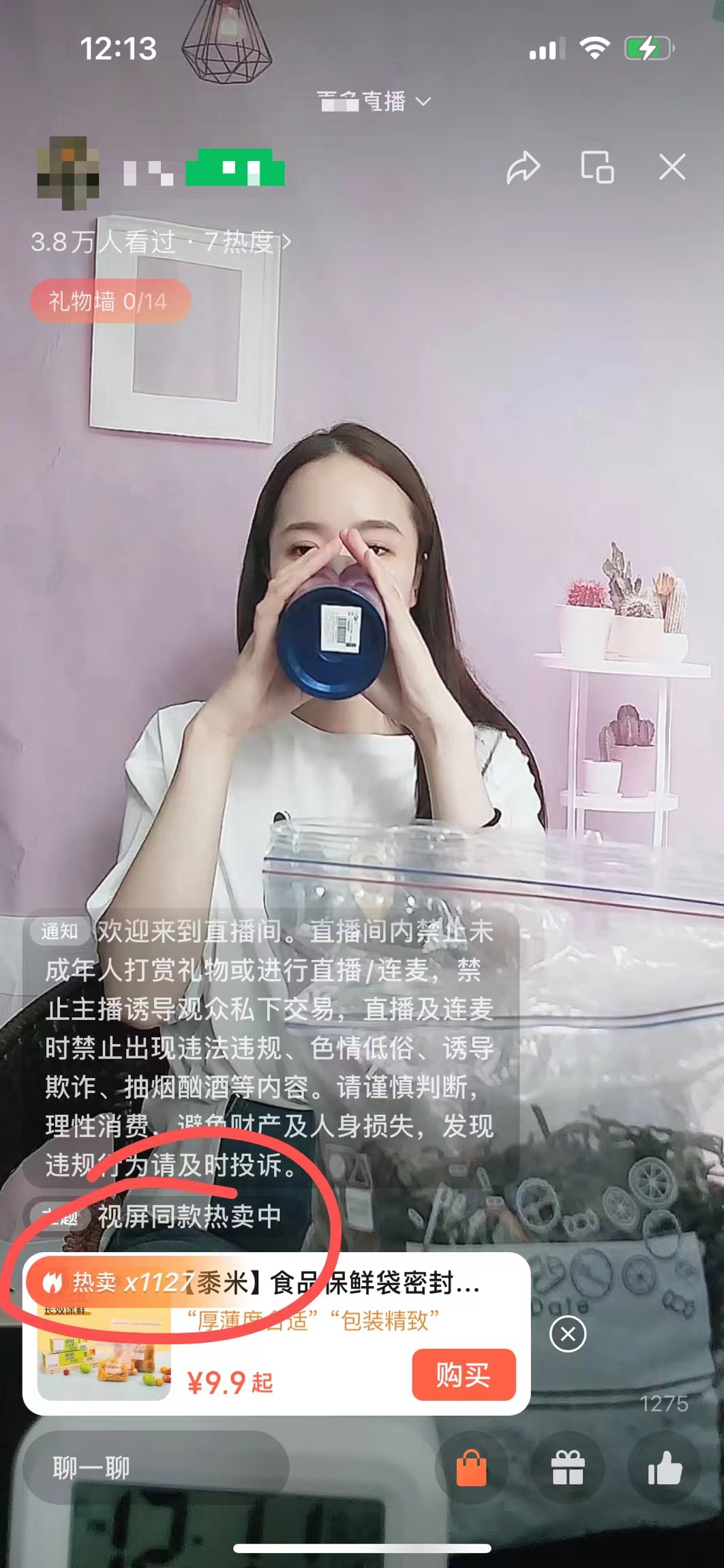 图片展示的是一场带货直播画面。画面中女主播正在用手中的蓝色容器喝水，背景为粉色墙面及白色置物架。屏幕下方有商品推荐栏，标注“热卖x112【装米】食品保鲜密封罐...”，售价9.9元起，并有“包装精致”的评价。左上角显示有3.8万人看过，还标注了“礼物榜0/14”。该图片与上下文关系为：作为案例展示，印证上文提到的数字人口播带货中直播带货环节，体现带货商品及直播相关数据情况。