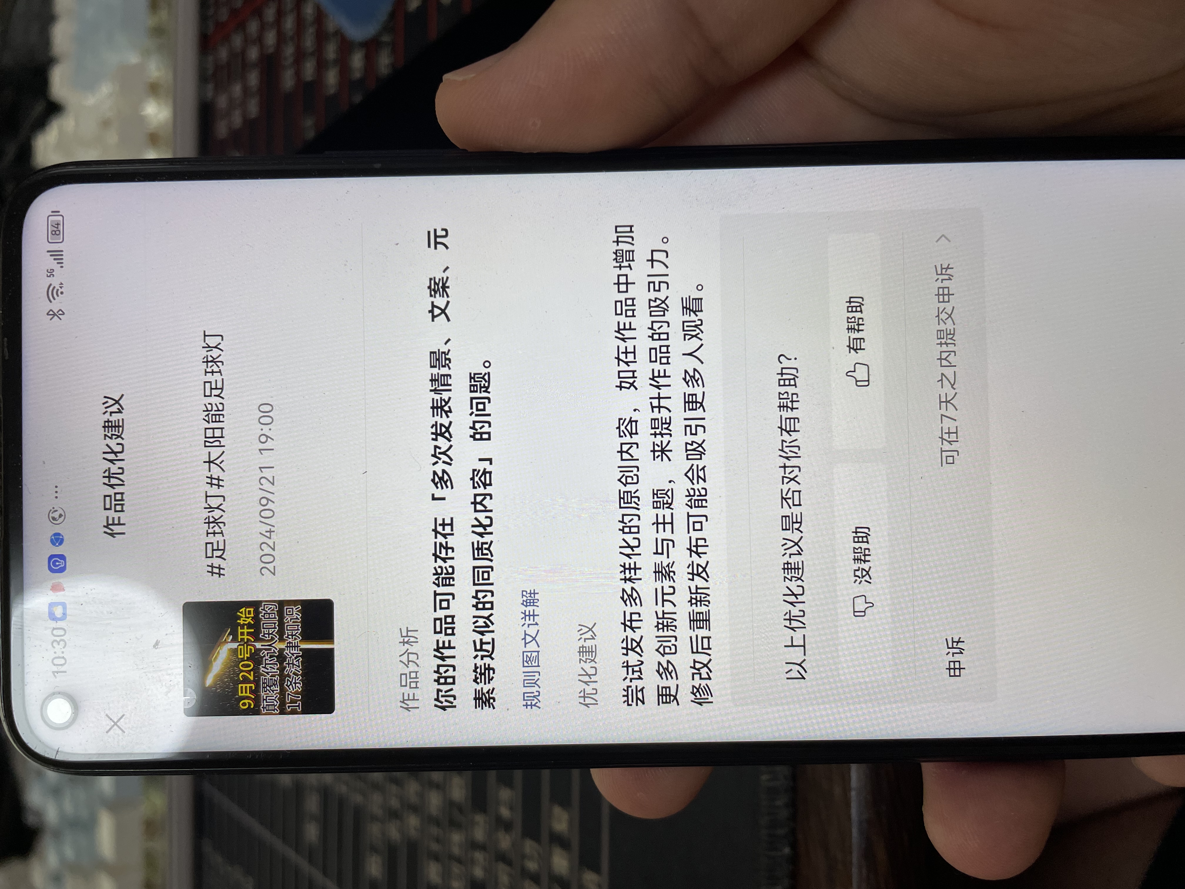 这张图片展示的是一台手机界面，内容为平台针对用户作品推送的优化建议，关联的作品带有“#足球灯#太阳能足球灯”的标签，发布时间为2024年9月21日19:00。作品分析指出，该作品存在“多次发表情景、文案、元素等近似的同质化内容”的问题。优化建议说明，尝试发布多样化原创内容，在作品中增加更多创意元素与主张，可提升作品吸引力，修改后重新发布更容易吸引更多人观看。该内容对应文档中“视频剪辑”板块里关于剪辑及作品去重的相关要求，是解决短视频同质化问题的相关指引说明。