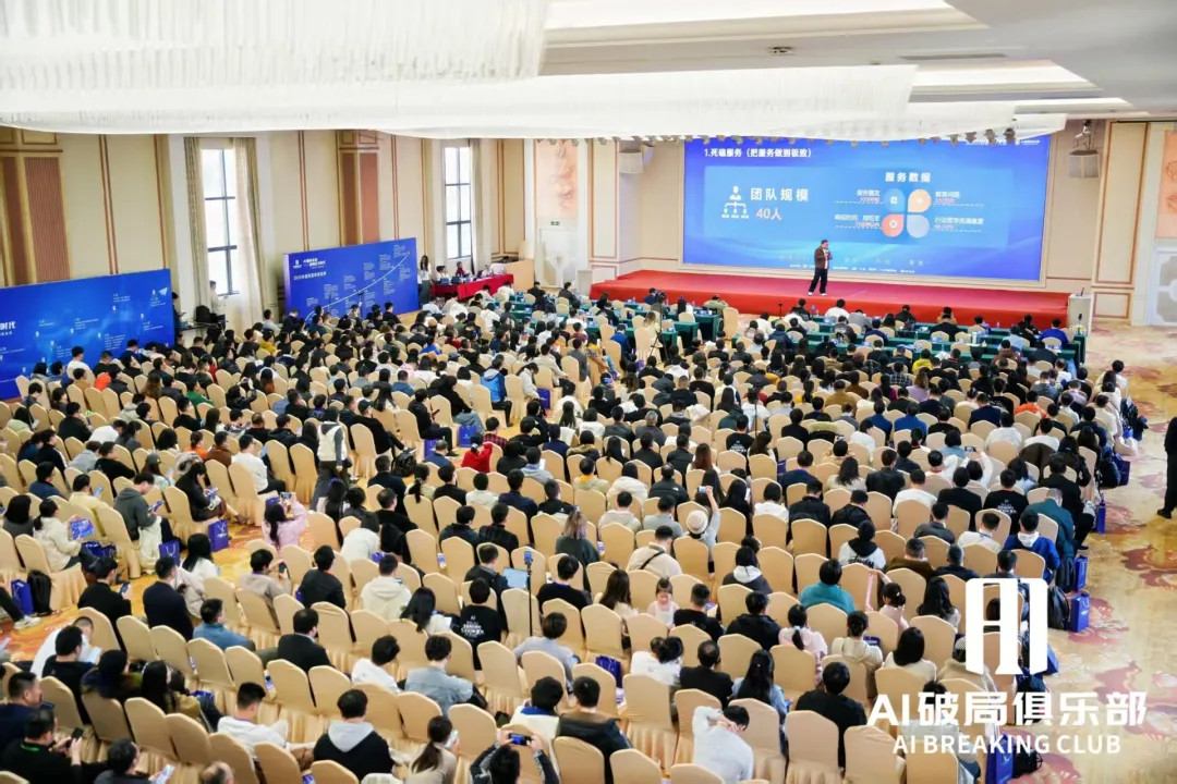 图片展示的是深圳破局线下大会现场。会场内座无虚席，观众席上坐满了人，部分观众面带笑容。舞台背景板上显示“AI破局俱乐部”“AI BREAKING CLUB”字样，还展示了“AI破局俱乐部”标识。舞台上有两位演讲者，一位在讲台上，另一位在台下。该图片与上下文紧密相关，直观呈现了前两天作者参加的近千人规模的破局线下大会盛况，与上下文提到的“前两天去深圳参加破局的线下大会，近千人规模，再创新高”相呼应。